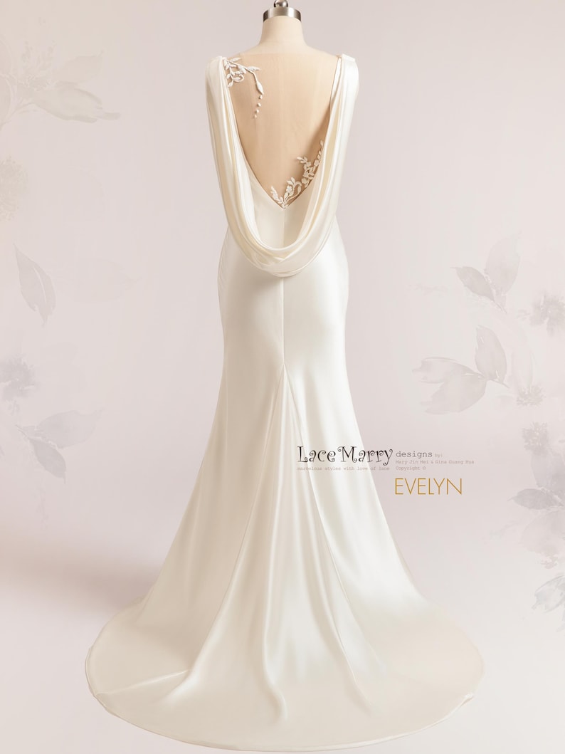 Pu&ograve; includere: Un abito da sposa in satin bianco con schiena scoperta e un pannello trasparente con delicati ricami floreali. L'abito ha una coda fluida e una scollatura a collo a scialle drappeggiato.
