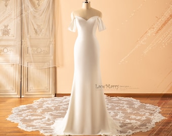 May include: A white off-the-shoulder wedding dress with a fitted bodice and a flowing skirt. The dress is displayed on a mannequin and has a lace train.
