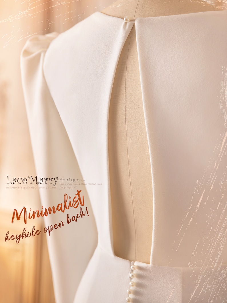 May include: A white wedding dress with a keyhole open back. The dress is on a white dress form. The text "Minimalist keyhole open back!" is superimposed on the image.