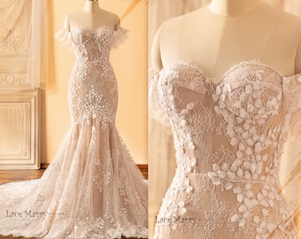 May include: A strapless wedding dress with a fitted bodice and a flowing skirt. The dress is made of lace and features delicate floral appliques. The dress has a sweetheart neckline and a train.
