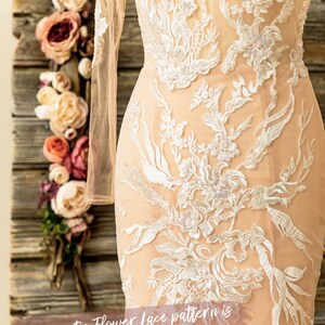 May include: A close-up of a white lace wedding dress with a floral pattern. The dress has long sleeves and a fitted bodice. The text "Lace Marry designs" and "Romantic Flower Lace pattern is Truly One of a Kind!" is visible on the image.