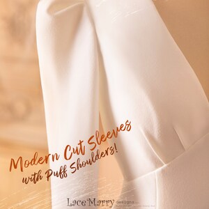 May include: A white dress with a modern cut sleeve design and puff shoulders. The text "Modern Cut Sleeves with Puff Shoulders!" and "Lace Marry designs" is visible on the dress.