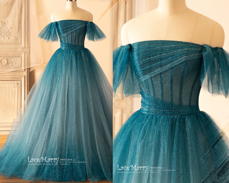 K&ouml;nnte beinhalten: Ein blaues T&uuml;ll-Ballkleid mit herzf&ouml;rmigem Ausschnitt und schulterfreien Tr&auml;gern. Das Oberteil ist mit Pailletten verziert und der Rock ist aus mehreren Lagen T&uuml;ll gefertigt. Das Kleid hat ein figurbetontes Oberteil und einen weiten Rock. Das Kleid ist perfekt f&uuml;r einen formellen Anlass.