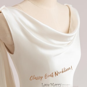 Pu&ograve; includere: Primo piano di un abito bianco in satin con scollo a barca. Lo scollo &egrave; drappeggiato e ha un effetto a scialle. Il testo "Classy Boat Neckline! Lace Marry designs by Mary Ji Mei & Gina Guang Niu.  Beautiful styles with love of lace. Copyright &copy; EVELYN" &egrave; visibile sull'abito.