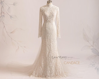 May include: A white lace wedding dress with a high neck, long sleeves, and a fitted silhouette. The dress has a lace pattern throughout and a train. The dress is labeled "Lace Marry designs" and "CANDACE".