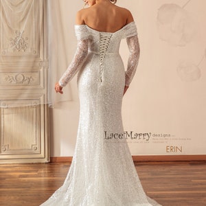 May include: A white off-the-shoulder sequined wedding dress with long sleeves and a lace-up back. The dress has a fitted bodice and a flowing skirt. The dress is designed by Lace Marry.