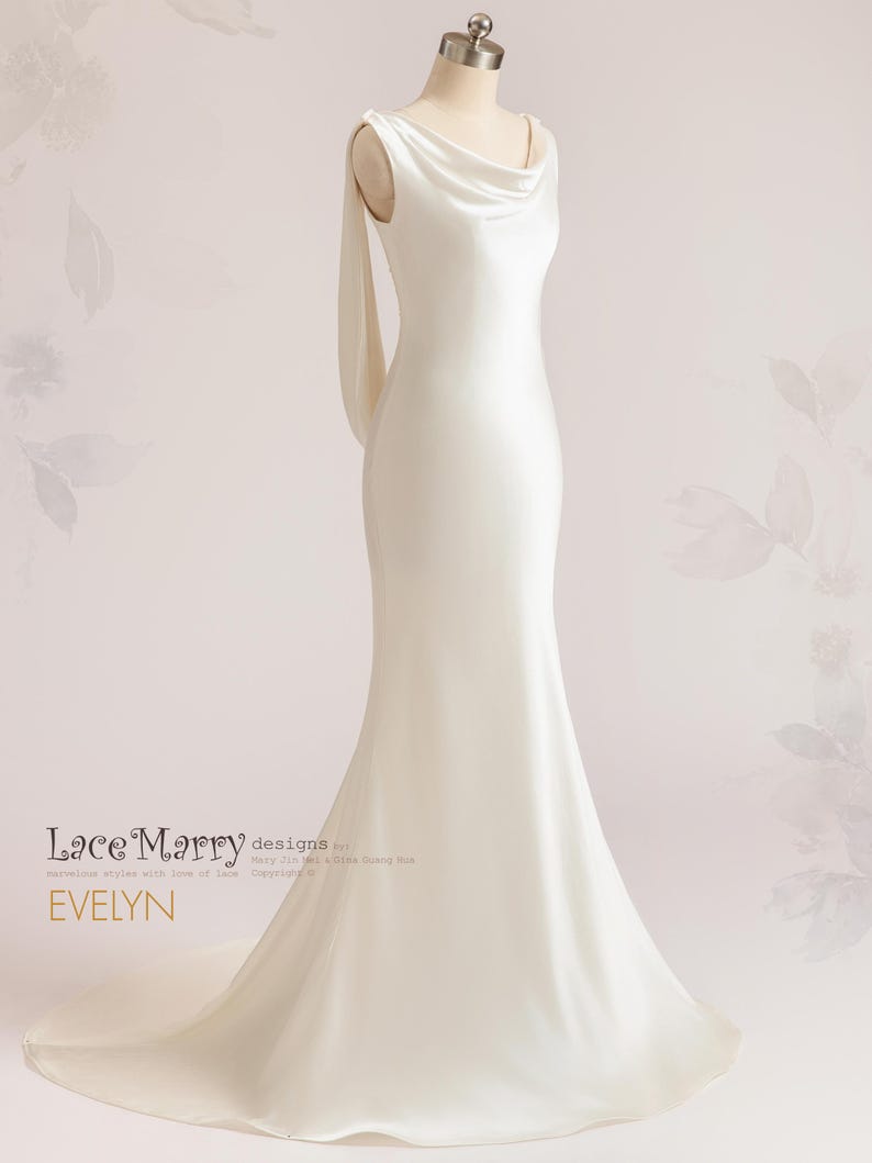 Pu&ograve; includere: Un abito da sposa in raso bianco con scollo a barca e una lunga coda. L'abito ha un design semplice ed elegante, perfetto per una sposa moderna.