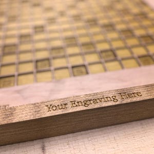 May include: A wooden board with a grid pattern and the text "Your Engraving Here" engraved on the bottom edge.