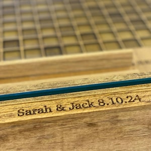 K&ouml;nnte beinhalten: Eine Holzkiste mit Glasdeckel, graviert mit dem Text "Sarah & Jack 8.10.24".