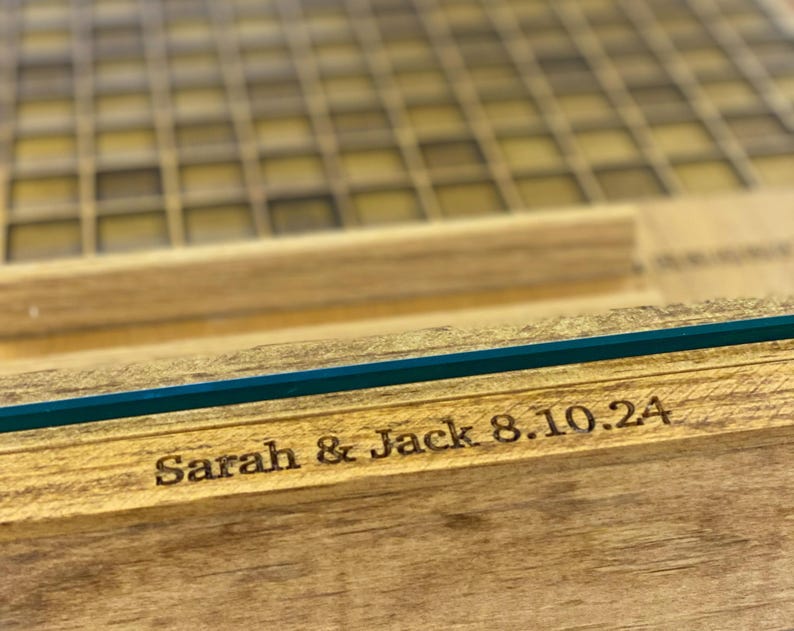 K&ouml;nnte beinhalten: Eine Holzkiste mit Glasdeckel, graviert mit dem Text "Sarah & Jack 8.10.24".