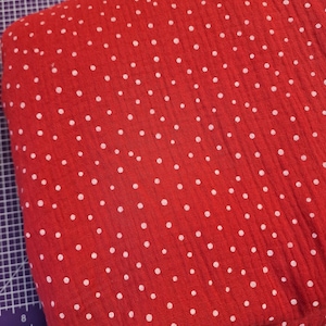 Pu&ograve; includere: Tessuto rosso con pois bianchi. Il tessuto ha un aspetto testurizzato e stropicciato.
