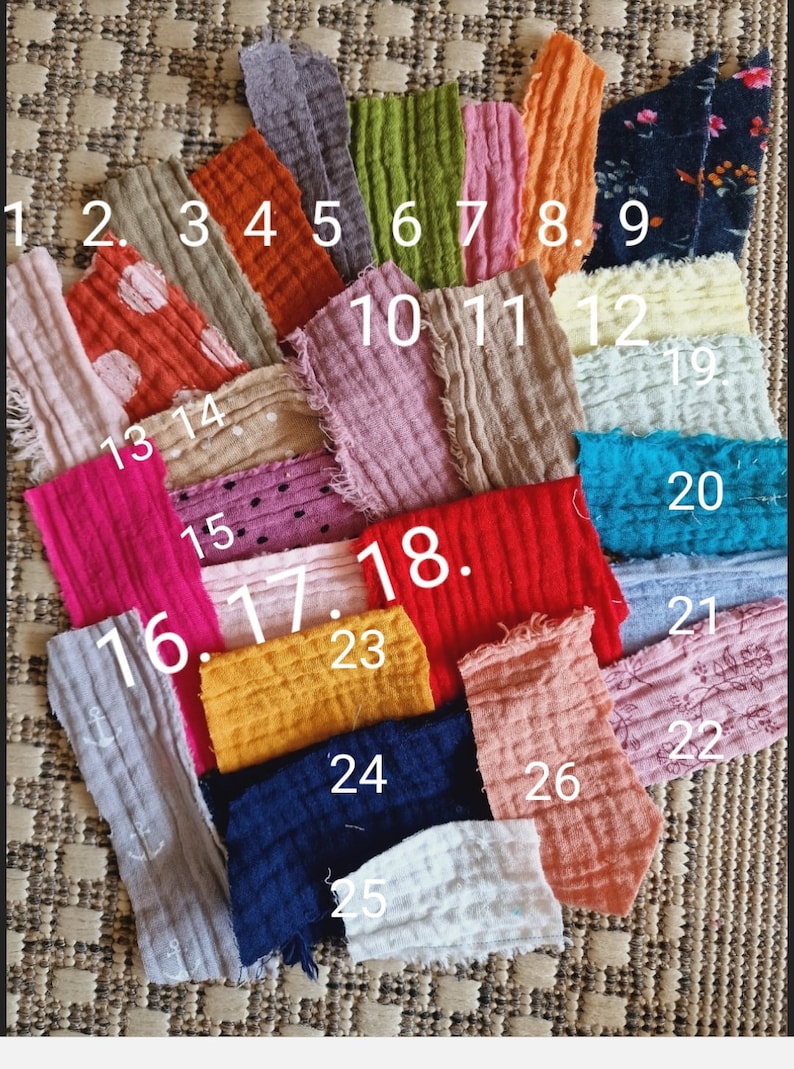 Pu&ograve; includere: Una collezione di 26 campioni di tessuto in vari colori e motivi, tra cui colori solidi, pois e stampe floreali. I campioni sono numerati da 1 a 26.