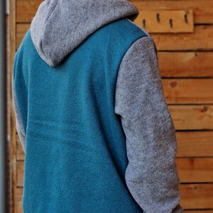 May include: A teal blue and gray hooded sweatshirt with a contrasting color on the sleeves and hood.