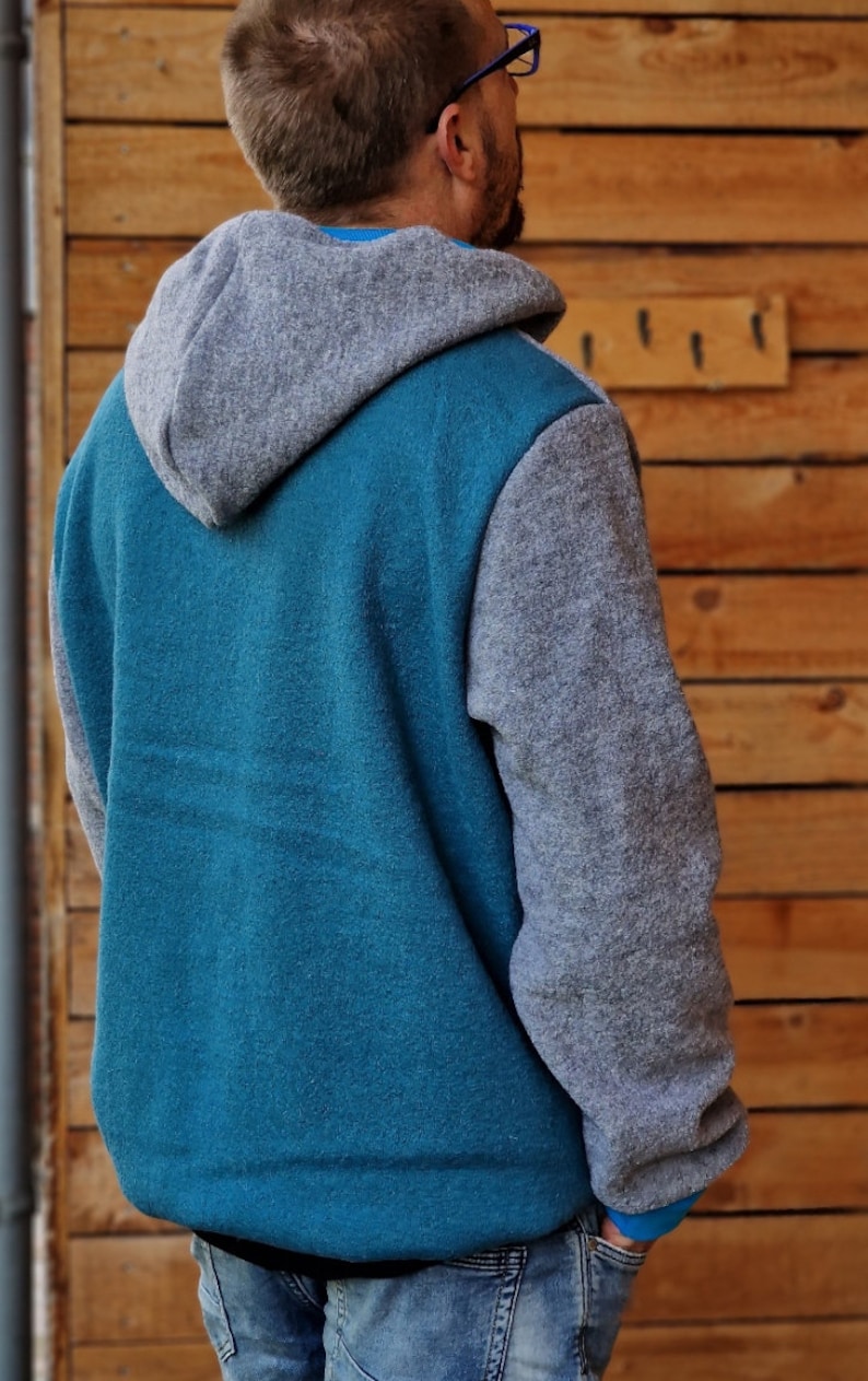 May include: A teal blue and gray hooded sweatshirt with a contrasting color on the sleeves and hood.