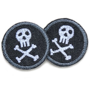 Könnte beinhalten: Zwei schwarze und weiße gestickte Bügelbilder mit einem Totenkopf- und Knochenkreuz-Motiv. Die Patches sind rund und haben einen grauen Rand.