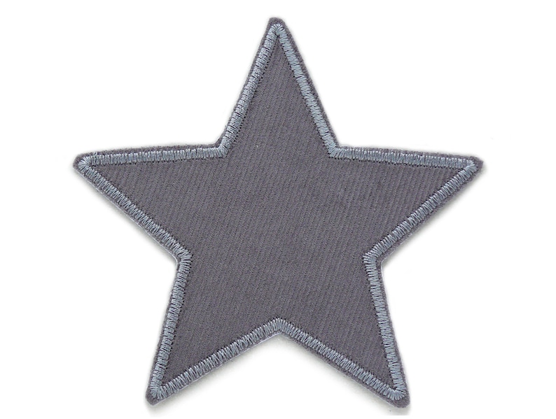 Puede incluir: Un parche gris en forma de estrella con un contorno gris claro. El parche est&aacute; hecho de una tela suave y texturizada.