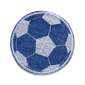 Könnte beinhalten: Ein runder, gestickter Aufnäher mit einem Fußball-Design. Der Ball ist aus blauem Denim-Stoff mit weißen Nähten, die die sechseckigen Paneele umreißen. Der Aufnäher hat einen weißen, genähten Rand.