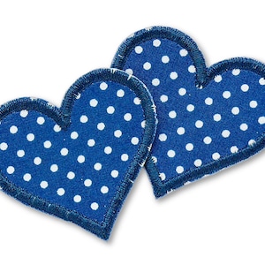 May include: Two blue fabric hearts with white polka dots. The hearts are sewn together.