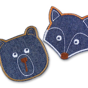 May include: Two denim patches, one a bear and the other a fox. The bear is navy blue with a brown outline and nose. The fox is navy blue with an orange outline and a brown nose. Both have white embroidered details, ideal for children's clothing.