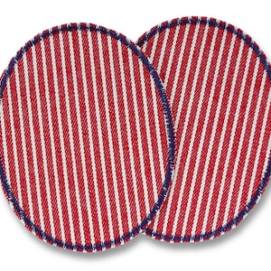 Może przedstawiać: Dwa owalne podkładki pod szklanki z czerwono-białym wzorem w paski. Krawędzie wykończone są ciemnoniebieską, szytą obwódką. Podkładki chronią powierzchnie przed kondensacją.