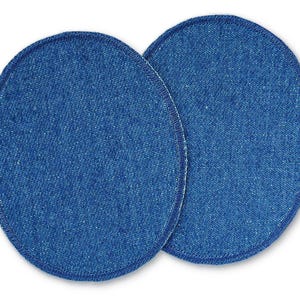 Könnte beinhalten: Zwei runde Jeans-Patches mit einem genähten Rand. Die Patches sind mittelblau.