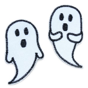 Könnte beinhalten: Zwei weiße, ghostförmige Bügelbilder mit schwarzen Umrissen und Gesichtszügen.