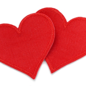 Può includere: Due cuori di feltro rosso cuciti insieme. I cuori si sovrappongono leggermente.