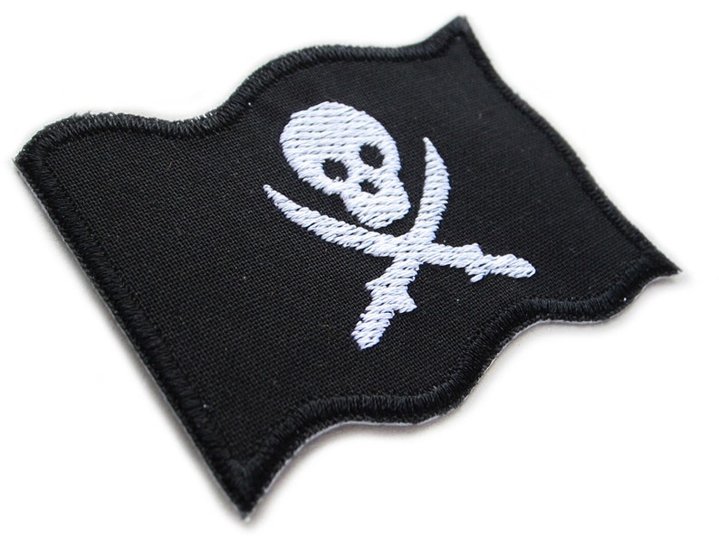 Peut inclure: Un patch de drapeau de pirate en tissu noir avec un motif de cr&acirc;ne et d'os crois&eacute;s blancs. Le drapeau est brod&eacute; et a un bord ondul&eacute;.