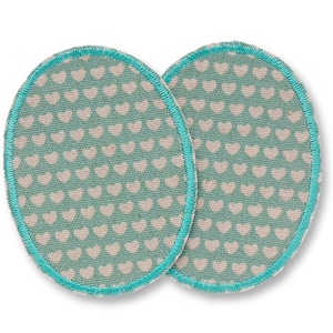 May include: Two oval patches with a teal background and a pattern of small white hearts. Each patch has a teal stitched border. These patches could be used for decoration or to repair clothing.