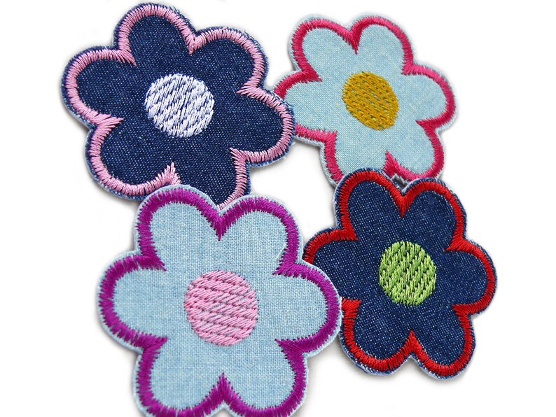 May include: Four denim flower patches with different colored embroidery. The flowers are blue, light blue, and dark blue with pink, red, yellow, and green embroidery.