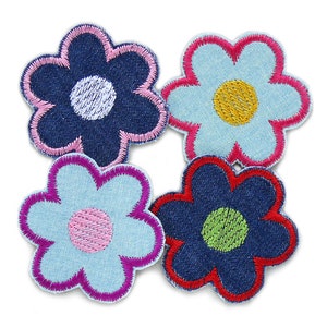 May include: Four denim flower patches with different colored centers. The flowers are blue, light blue, and dark blue with pink, yellow, and green centers.