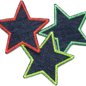 May include: Three denim star-shaped patches with contrasting coloured stitching. The top star has red stitching, the middle star has green stitching, and the bottom star has neon green stitching.