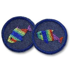 Può includere: Due toppe rotonde ricamate blu navy. Ogni toppa presenta un colorato disegno di pesce arcobaleno. I pesci sono ricamati con fili vibranti, tra cui rosso, arancione, giallo, verde, blu e viola. Le toppe sono probabilmente per abbigliamento o accessori.