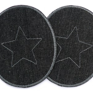 May include: Two black denim patches with a white star stitched in the centre. The patches are oval shaped and have a grey stitched border.
