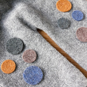 Può includere: Pantaloni della tuta grigi con cerchi di feltro in vari colori, tra cui arancione, marrone, blu e grigio.