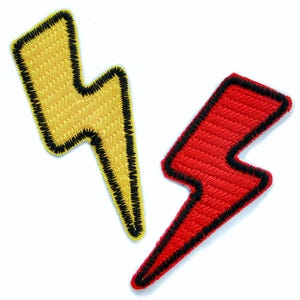 May include: Two embroidered iron-on patches in the shape of lightning bolts. One is yellow with a black outline, and the other is red with a black outline.