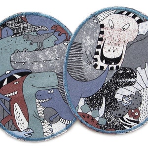 May include: Two round fabric patches with a dinosaur theme. The patches are blue, gray, and brown with a variety of dinosaurs, including a T-Rex, a stegosaurus, and a triceratops.
