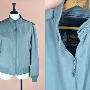 May include: A gray London Fog jacket with a zipper closure and a button on the collar. The jacket has a label that reads "London Fog" with a small image of a building.