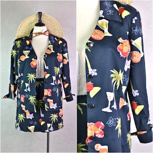 May include: A black and white tropical print skirt and jacket set. The fabric features palm trees, cocktails, and fruit.
