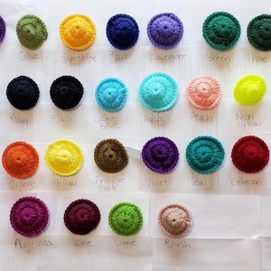 May include: A collection of 30 small crocheted circles in various colors, including red, blue, green, yellow, purple, and orange. Each circle has a different color and is labeled with its corresponding color name.
