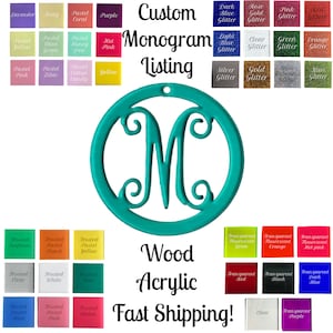 May include: A teal blue round ornament with a white letter M in the center. The ornament is made of wood or acrylic. The image shows a variety of color options for the ornament, including frosted, pastel, glitter, and transparent.