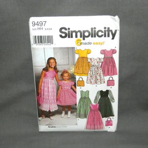 May include: A Simplicity sewing pattern envelope, number 9497, size HH 3, 4, 5, 6. The front displays two children wearing dresses and illustrations of various dress styles with short or long sleeves, some with matching handbags, in floral, plaid, and solid patterns.