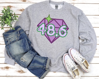 Könnte beinhalten: Hellgraues Sweatshirt mit einem lila und grünen Diamant-Grafik, auf dem "dopey miles 48.6" steht. Das Bild zeigt auch blaue Jeans und weiße Turnschuhe. Der Text "Sport Grey" befindet sich unten.