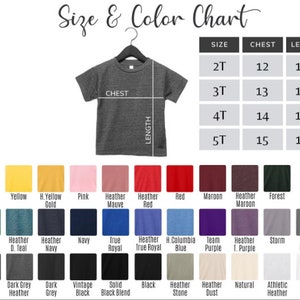 Pu&ograve; includere: Tabella delle taglie e dei colori per t-shirt con misure in pollici per il petto e la lunghezza. La tabella mostra le taglie 2T, 3T, 4T e 5T. La tabella dei colori mostra una variet&agrave; di colori, tra cui giallo, rosa, rosso, marrone, blu navy, blu, viola, grigio, nero e bianco.