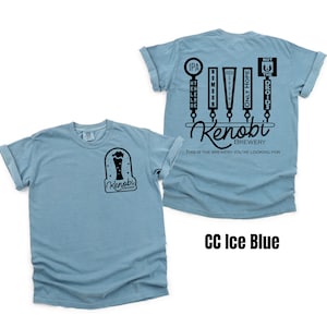 May include: A light blue t-shirt with a black graphic of a beer tap with different beer names, including "IPA", "High Ground", "Only Hope", and "Not the Droids". The graphic also includes the text "Kenobi Brewery" and the tagline "This is the brewery you're looking for". The front of the shirt has a smaller black graphic of a beer glass with the text "Kenobi Brewery".