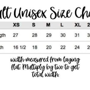 May include: A size chart for adult unisex clothing. The chart shows measurements in inches for body length and width for sizes XS, S, M, L, XL, 2XL, and 3XL. The text below the chart reads "width measured from laying flat. Multiply by two to get total width."