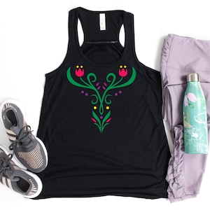 May include: Black racerback tank top with a floral design in green, pink, purple, and yellow. The tank top is paired with gray sneakers, lavender leggings, and a floral water bottle.