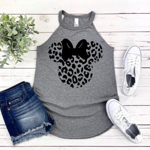 Op de afbeelding: Een grijs tanktop met een zwart-wit luipaardprint Minnie Mouse-ontwerp. Het tanktop heeft een racerback-stijl en is gemaakt van een zachte, comfortabele stof.