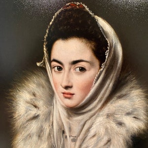 May include: A portrait painting of a woman wearing a white fur-trimmed shawl and a white head covering. The woman has dark hair and brown eyes. The background is a dark brown.