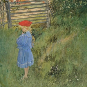 May include: A young girl in a blue dress and red hat stands in a grassy field. She is looking down at something in her hands. There is a wooden fence and gate behind her.
